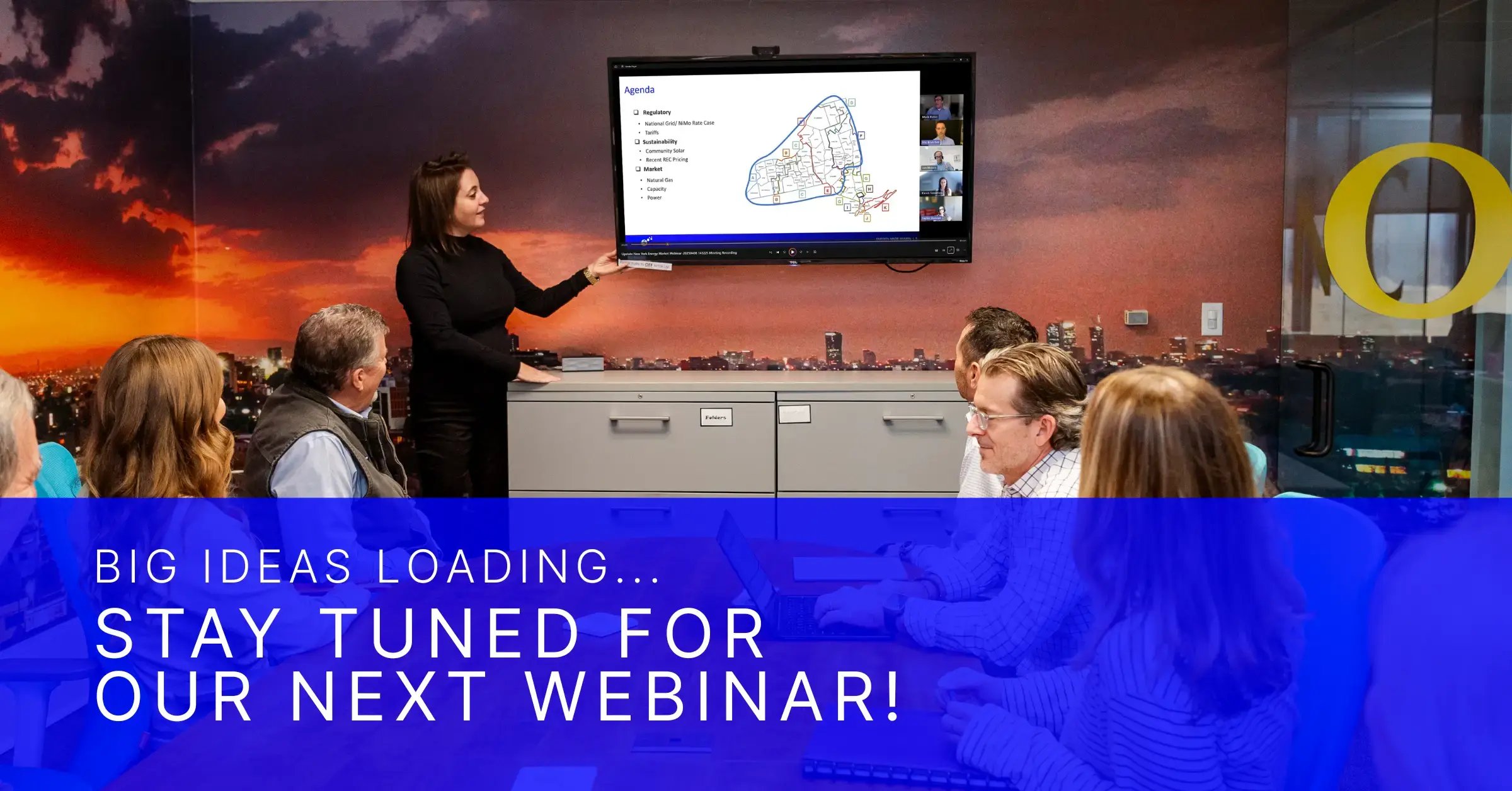 Team members gathered in a conference room during a webinar presentation with text reading “Big Ideas Loading… Stay Tuned for Our Next Webinar!”