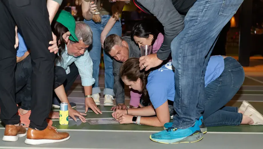 Group collaborating closely around a task during a workplace team-building event