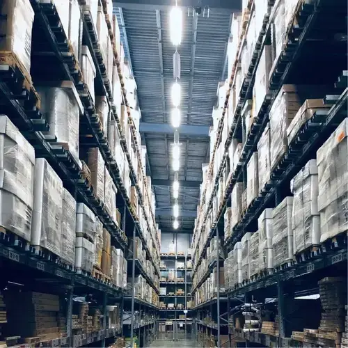 Warehouse aisle with tall shelves stacked with boxes and pallets