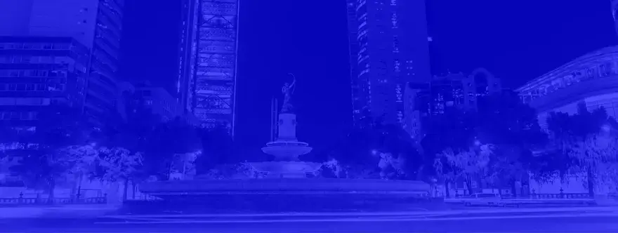 Diana the Huntress fountain at night on Paseo de la Reforma in Mexico City with illuminated skyscrapers