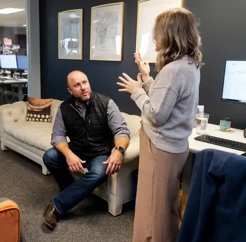 Two colleagues discussing ideas in an office workspace
